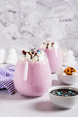 Fresh berry yogurt with marshmallows and icing in glasses on table vertical view