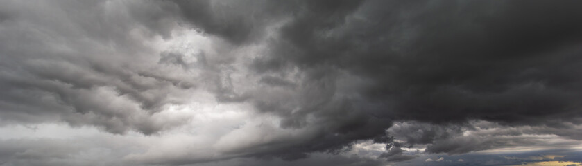 The ominous dark sky,laden with swirling cloud,signal the arrival of fierce windstorm,highlighting...