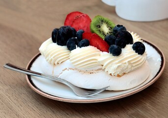 meringue white cake with colorful fruits close up