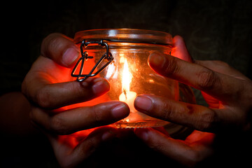 Hands Holding a Candle in a Glass Jar