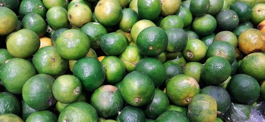 Pile of lime or lemon fruits background ready to sell on the supermarket