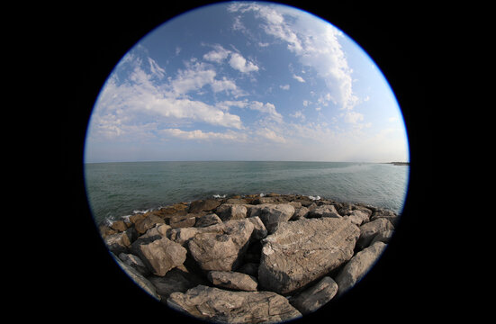 Fisheye lens view of sea and rocks with a dark vignette caused by the special type of lens creating a viewfinder effect