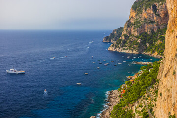 Experience the breathtaking coastal view featuring tranquil waters and majestic rocky cliffs in a Capri island