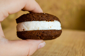a chocolate cookie sandwich filled with white cream food and beverage dessert products recipe cup of tea or coffee and a treat elegant tableware artisan cookies