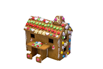 Gingerbread house made by children using ginger dough and decorated with colorful candies for Christmas celebration isolated on white background. Sweden.