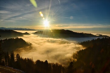 an island in the sea of ​​fog. an island in the sea of ​​fog. Beautiful autumn atmosphere at sunset on the Schnebelhorn. Enjoying the last rays of sunshine on the grassy hill. High quality photo.