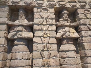 Close up detail of the relief facade of an ancient Babylonian temple with statues of fertility gods...