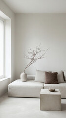 Minimalist living room with white walls, a gray sectional, and a small decorative table with a simple vase