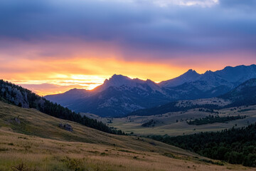 Obraz premium The sun is setting over the mountains, casting a warm glow over the landscape
