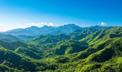 Naklejka premium A lush green mountain range under a clear blue sky, showcasing dramatic peaks and valleys