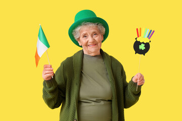 Happy senior woman in leprechaun hat with Irish flag and decor for St. Patrick's Day celebration on...