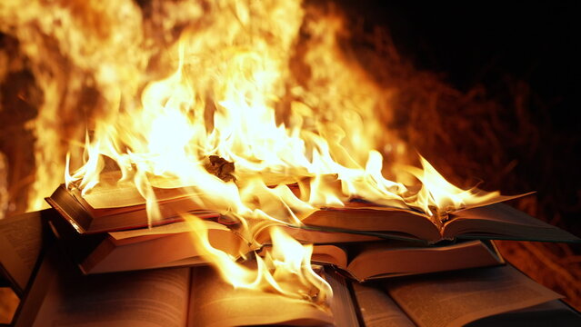 Open book is on fire, pages are engulfed in flames. Concept of censorship, prohibition of freedom information, 451 fahrenheit, old literature in paper format is no longer in demand.