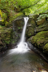 Fototapeta premium Long exposure of a waterfall on the Hoar Oak Water river at Watersmeet in Exmoor National Park