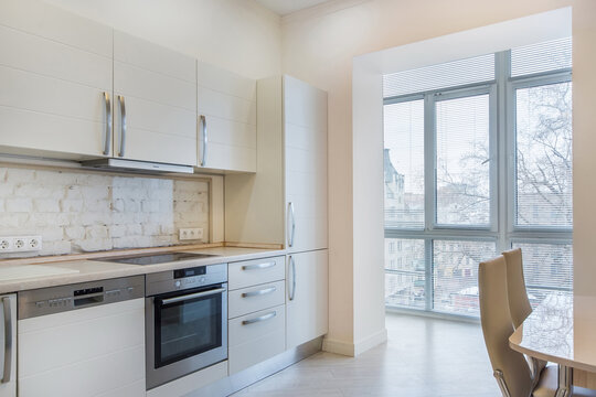 The kitchen is in pastel colors with a headset and access to a loggia with a panoramic window.