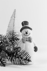 Festive New Year's decoration, decor from a ceramic snowman who has a red hat and a bow on the...