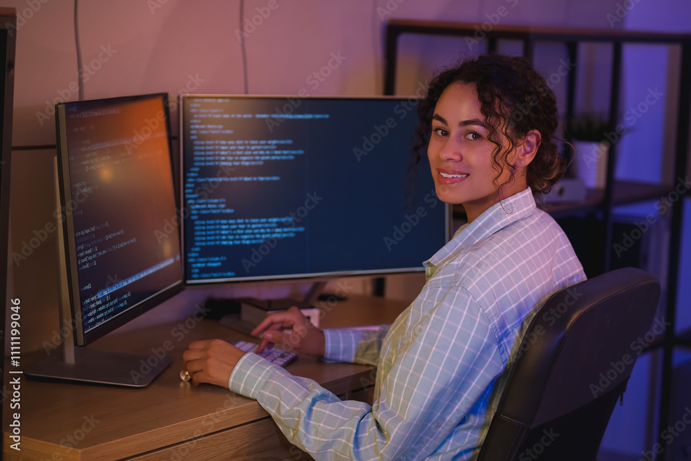 Aufkleber young african-american qa engineer working with computer in office at night