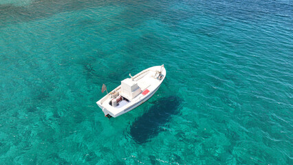 Aerial photo from traditional picturesque fishing boat on turquoise clear sea as seen from top in...