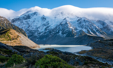 Obraz premium Stunning mountain landscape with clouds covering peaks mt cook new zealand national park winter snow peaks