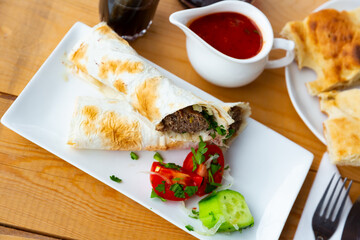 Traditional dish of Georgian cuisine is lula-kebab in lavash with vegetables, served with tomato sauce