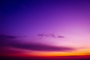 a purple sky with a purple and orange horizon and a purple cloud. Dramatic sky