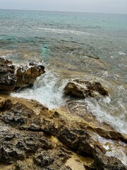 Waves Crashing Against Rocky Shoreline on a Cloudy Day