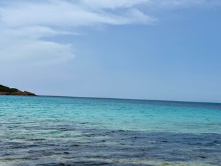 Clear Turquoise Waters under a Blue Sky on a Tranquil Beach in Sardinia, Italy