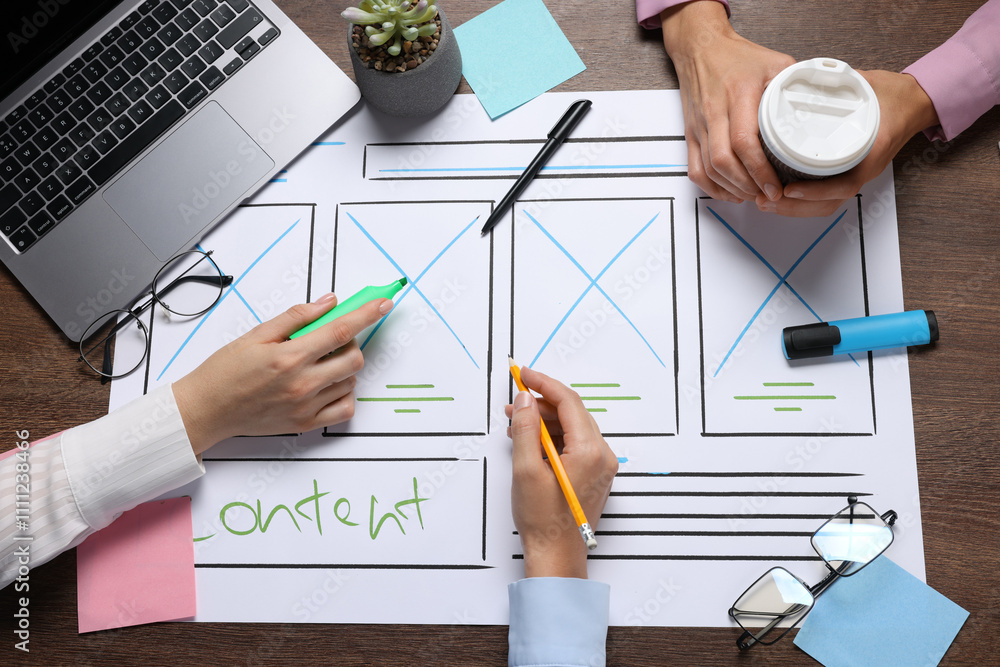 Fototapete developing ui design. designers creating website wireframe on paper at wooden table, top view