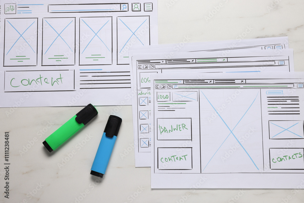 Poster developing ui design. sketches of website wireframes and felt pens on white marble table, top view