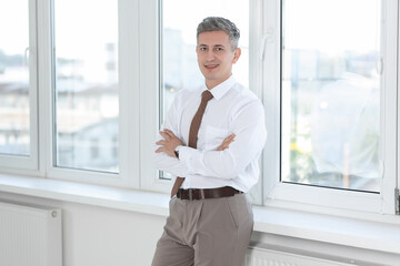 Portrait of businessman near window in office