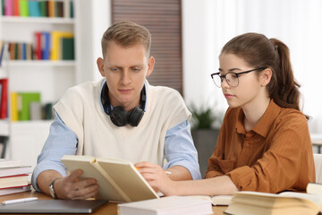 Students preparing for exam at table indoors