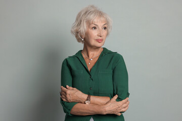 Portrait of beautiful senior woman on light grey background