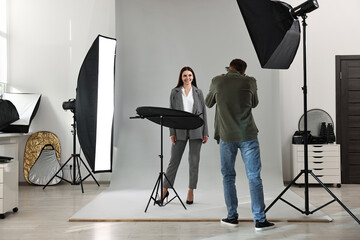 Photographer working with model in professional photo studio