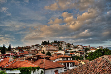 Historic residential buildings with red roofs in Ohrid Macedonia under a cloudy sky.