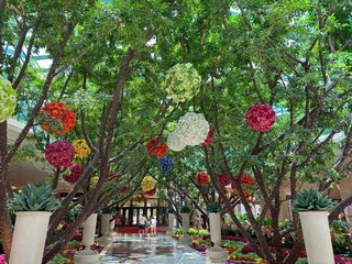 Indoor Garden Walkway with Hanging Floral Decorations in Luxury Hotel Atrium