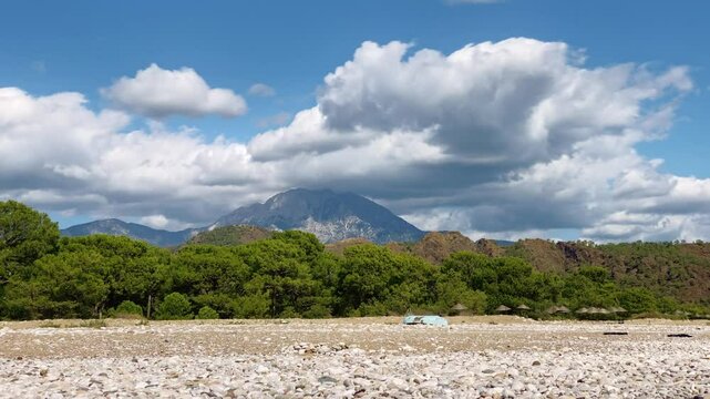 Cirali beach at Mediterranean sea. Tahtali mountain at background. Beach at sunny day In Antalya Province, Turkey.