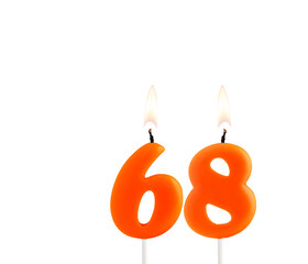 Lit birthday candle - Candle number 68 on white background.