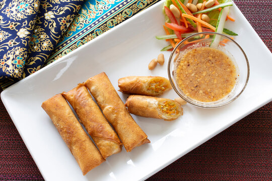Spring rolls are a very popular street food in Thailand. They are deep fried in a wok and served piping hot with sweet chili sauce.