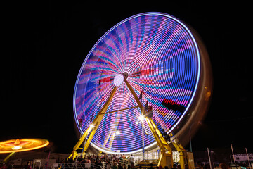A colorful merry go round with people on it