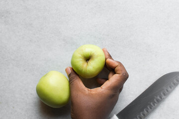 Overhead view of a whole green apple on a white granite countertop, top view of a crisp green apple on a white countertop