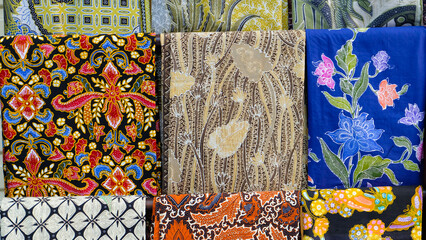 Colorful batik fabrics displayed in a market. Close-up shot highlights intricate patterns and vibrant colors. Perfect for fashion blogs or promoting Indonesian culture