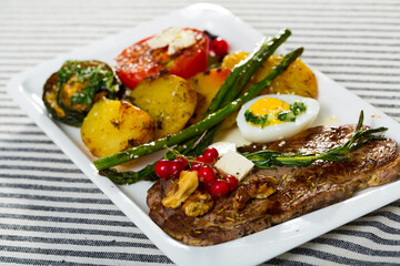 Photography of plate with baked veal with vegetables in restaurante.