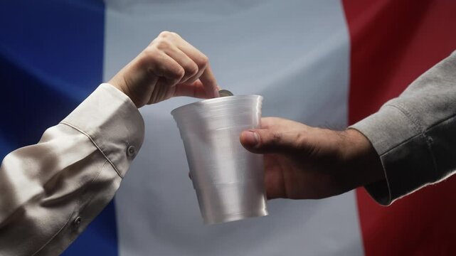 Rich European Woman Throws Cents Coin Into Plastic Cup Of Homeless Man Who Is Asking For alms on French flag. Sharing and help each other. Poor life, unemployment, people below poverty line.