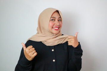 Beautiful smiling Asian woman in green sweater showing thumbs up gesture with hand isolated over white background