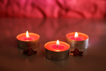 Illuminated tealight candles and red heart