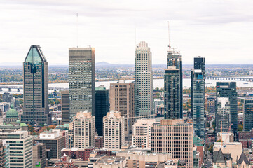 A vibrant view of Montreal’s downtown skyline with iconic skyscrapers, a backdrop of the St. Lawrence River, and a mix of modern and historic architecture.