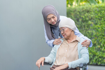 a young female health care worker in hijab take care senior cancer patient in wheelchair,talking,empowering,empathy,mental care in hospital