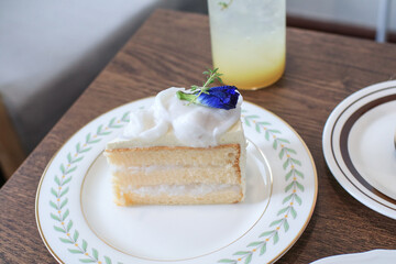Coconut cake with Cream vanilla and fresh coconut on top. Thai tradition Dessert on wooden table.