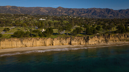 DECEMBER 2022, SANTA BARBARA, CA - USA - aerial view of famous Santa Barbara beach bluffs and with mountains and palm trees in background - near Montecito