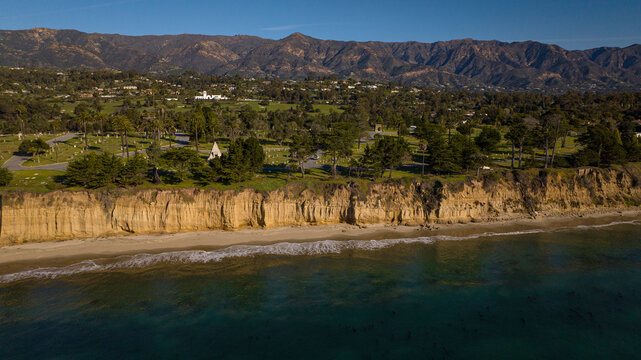 DECEMBER 2022, SANTA BARBARA, CA - USA - aerial view of famous Santa Barbara beach bluffs and with mountains and palm trees in background - near Montecito