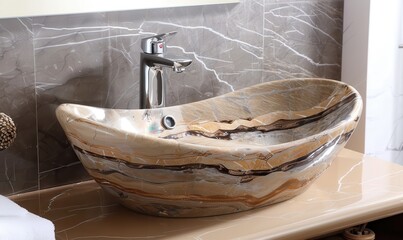 The design of the sink in the marble bathroom looks modern and easy to use.